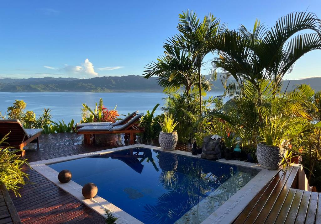 a swimming pool with a view of the water at Naveria Heights Lodge in Savusavu