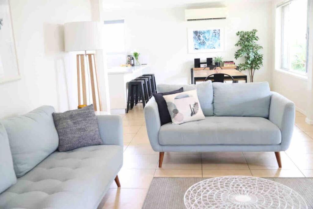 a living room with a couch and a table at Sunshine Coast Beach House - 2 mins to beach in Parrearra