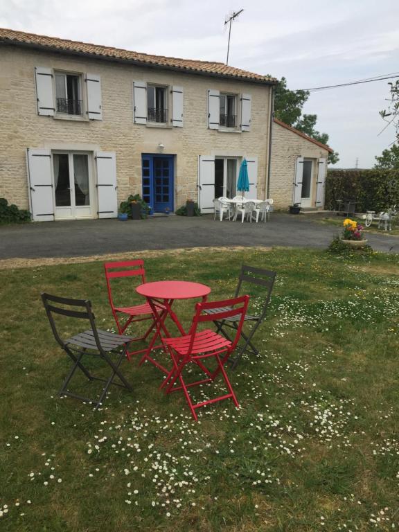 3 chaises et une table devant une maison dans l'établissement Belle longere 130 m2 aux portes du marais poitevin, à Niort