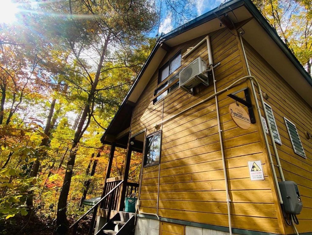 uma cabana na floresta com a porta aberta em Pyrenees Cottage - Vacation STAY 24861v em Hakuba