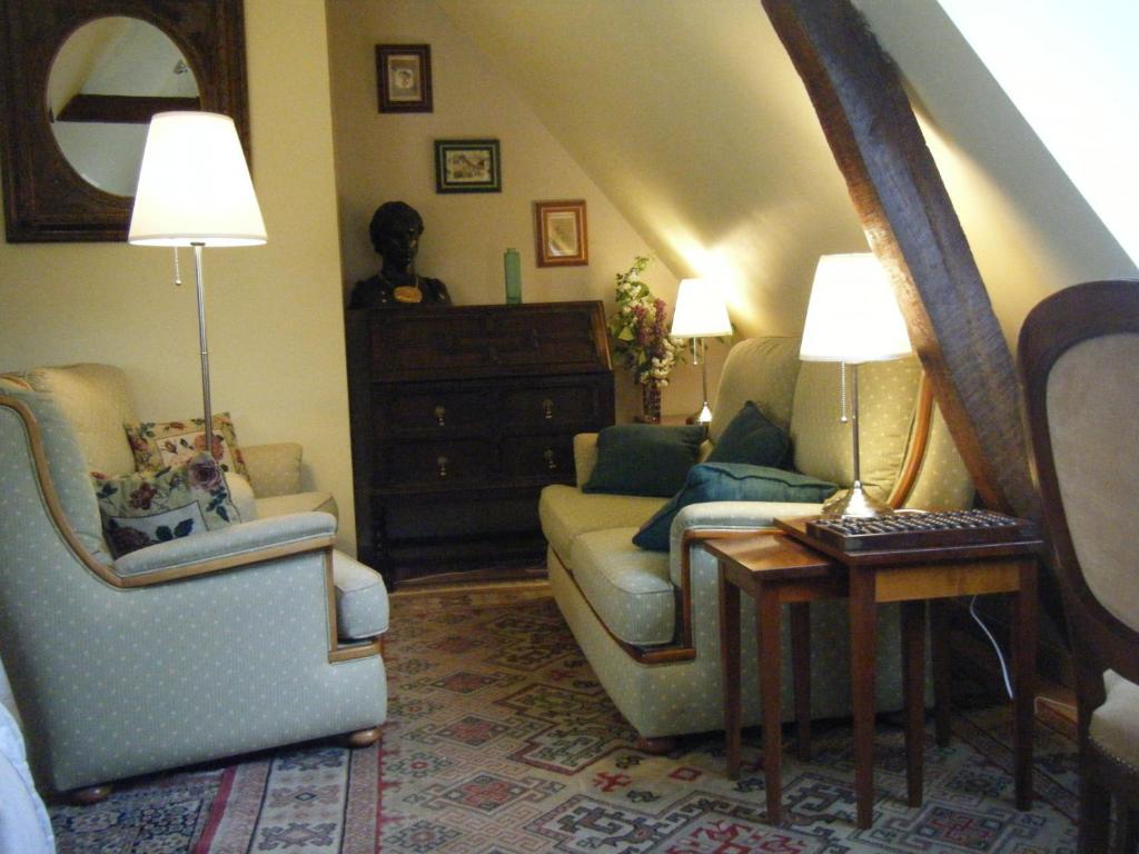 ein Wohnzimmer mit einem Sofa und 2 Stühlen in der Unterkunft La Longère Aux Sapins in Fontaine-le-Bourg