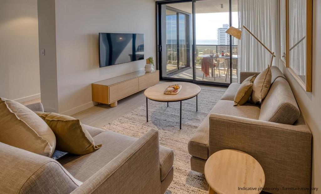 a living room with a couch and a table at Encore Broadbeach in Gold Coast