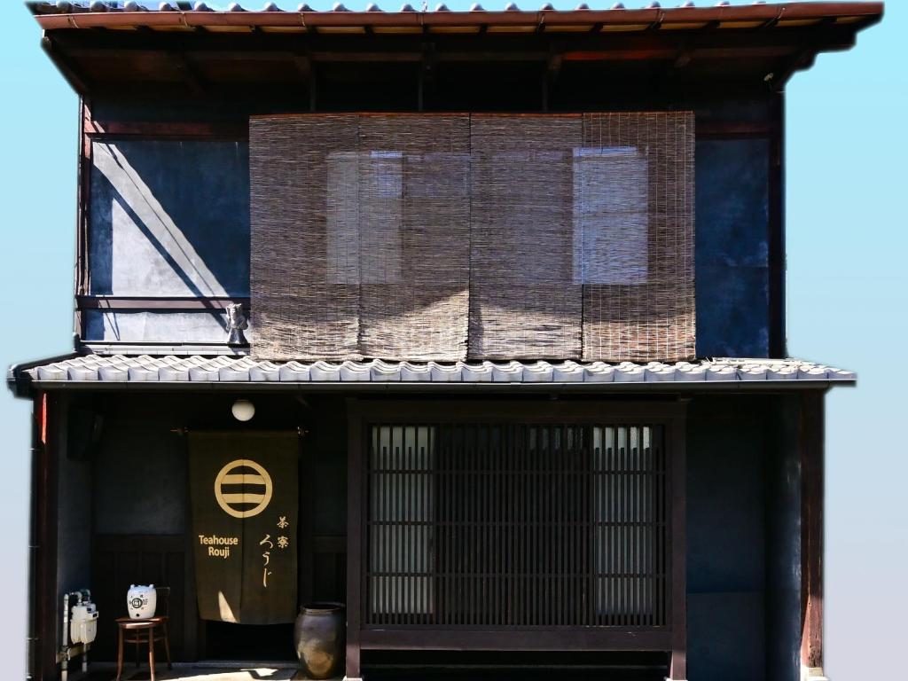 un edificio con un cartel en el costado en Teahouse Rouji, en Kioto