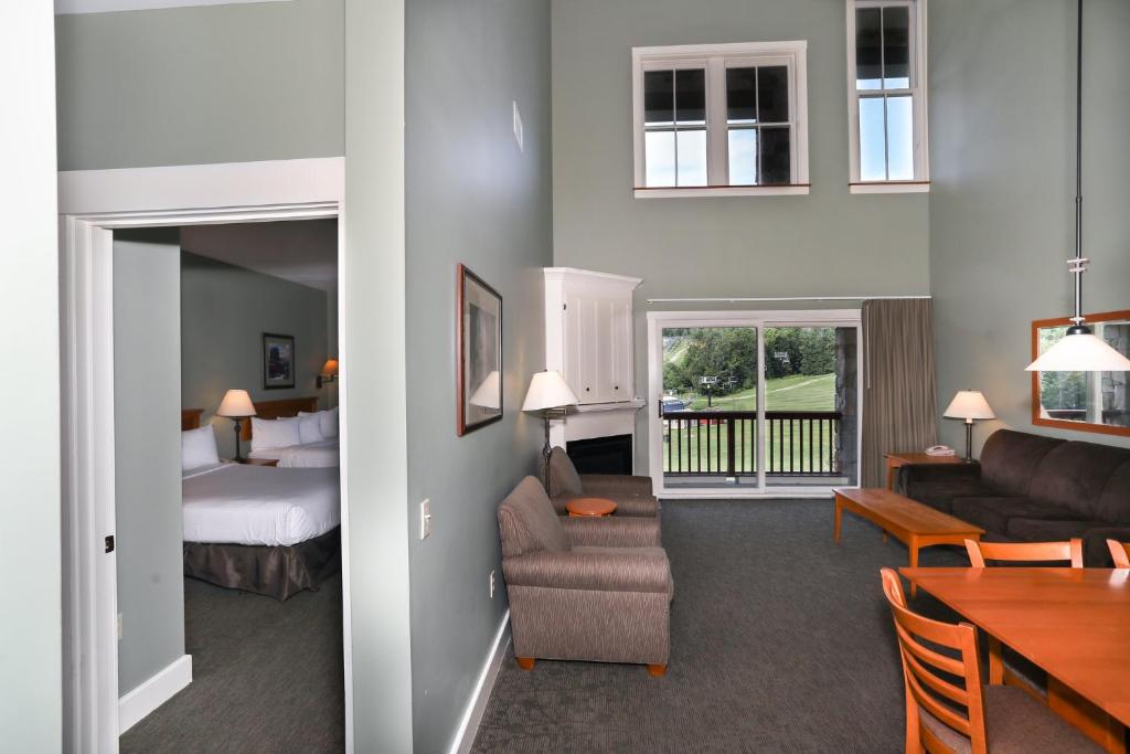 Habitación de hotel con cama y sala de estar. en Jackson Gore Village on Okemo Mountain en Ludlow