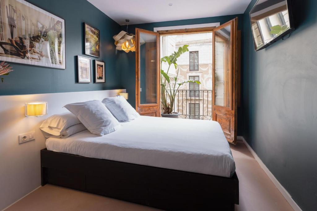 a bedroom with a large bed with a window at Hostal Sol y K in Barcelona