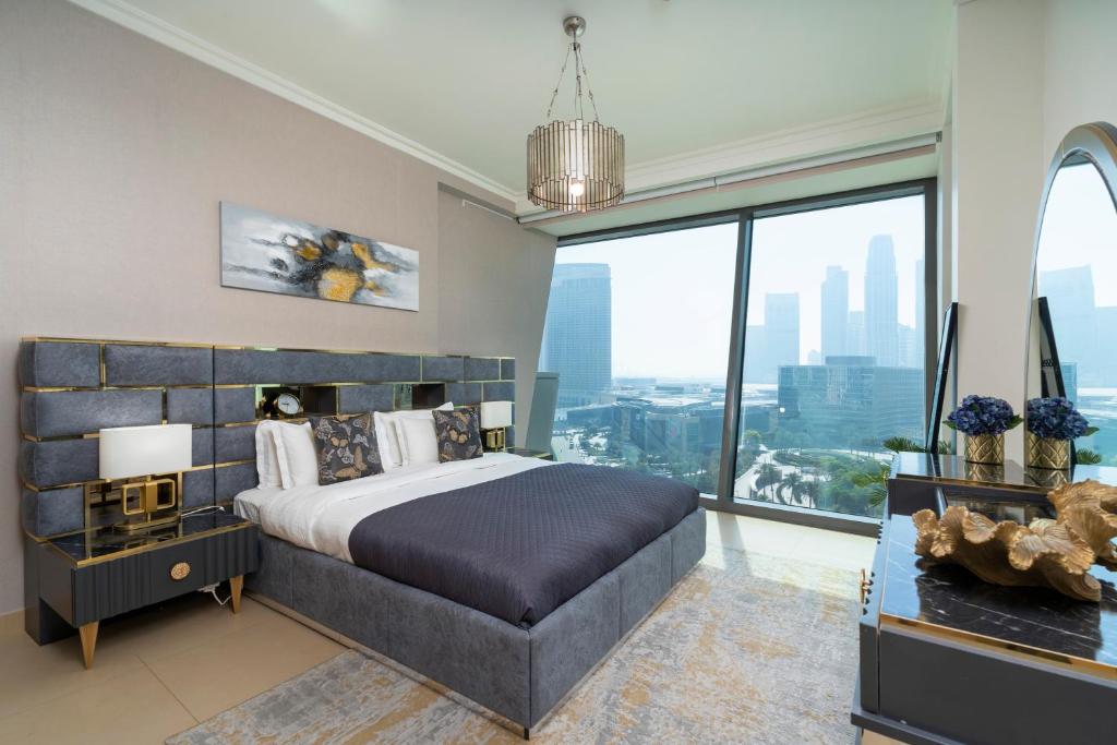 - une chambre avec un grand lit et une grande fenêtre dans l'établissement Prestige Living 1BR with Full Burj Khalifa View by Auberge, à Dubaï
