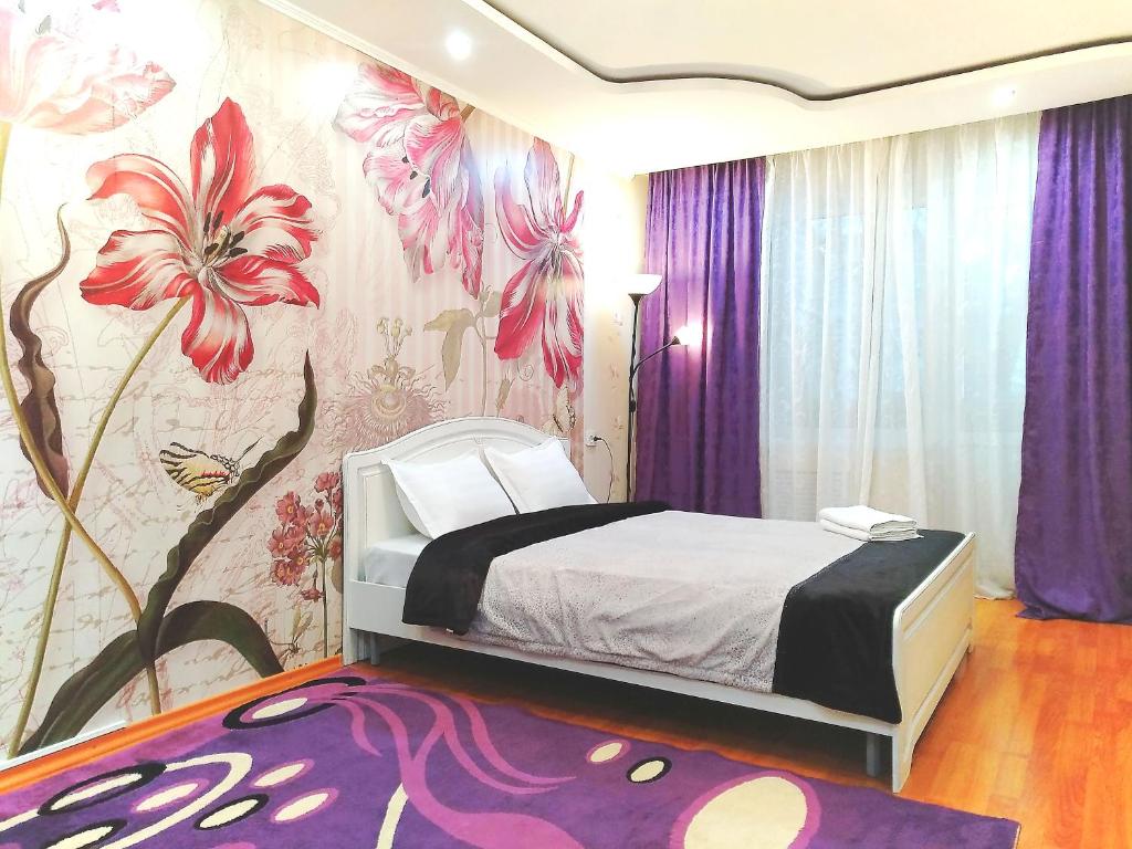 a bedroom with a bed with a flower mural on the wall at 429. Отличный вариант для туриста и командированного in Almaty