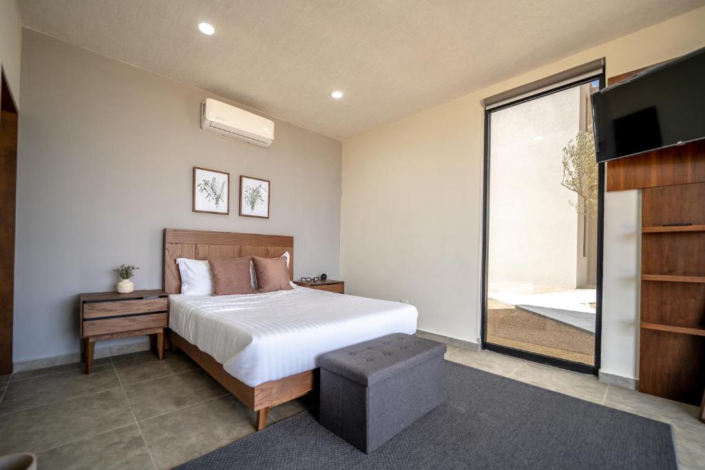 - une chambre avec un grand lit et une télévision dans l'établissement Villa Sophia Valle de Guadalupe, à Valle de Guadalupe