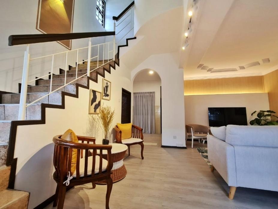 a living room with a staircase and a couch at Casablanca Holiday Home with BBQ Pit in Kuching