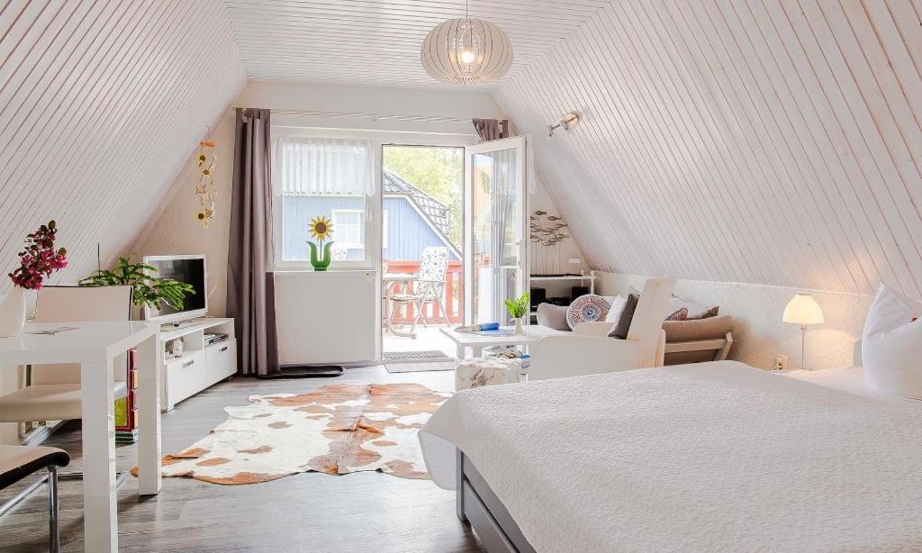 Biała sypialnia z łóżkiem, biurkiem i oknem w obiekcie Sonnenblumenhaus 02 w Prerowie