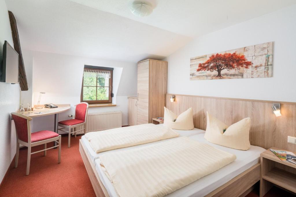 a hotel room with a bed and a desk at Spree-Pension in Bautzen
