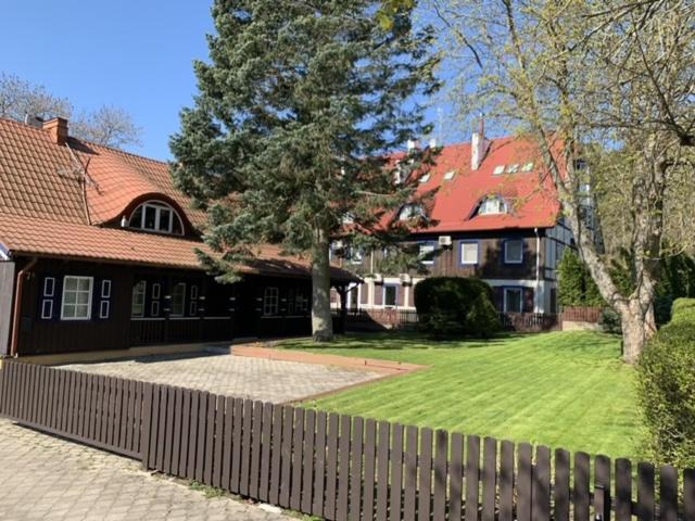 a house with a fence in front of a yard at Vila Nidutė in Nida