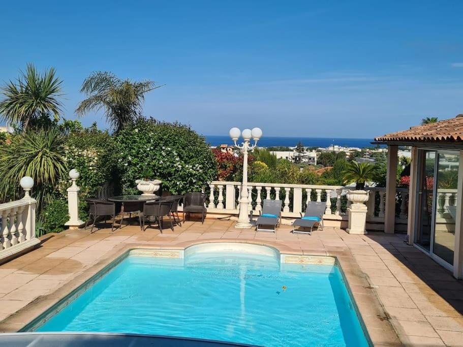 basen na patio ze stołem i krzesłami w obiekcie Villa Valentino - Vue mer- Pool House / Piscine w mieście Antibes