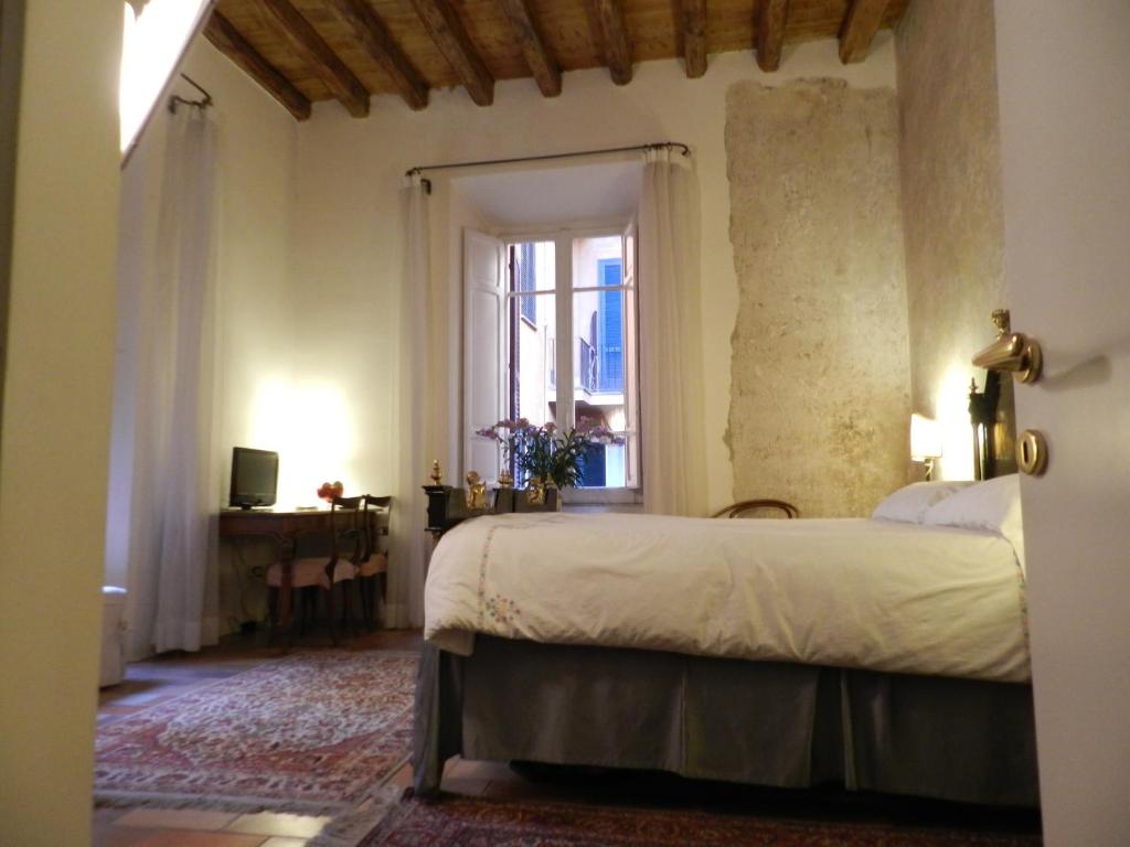 Schlafzimmer mit einem Bett und einem Fenster in der Unterkunft Vicolo del Lupo Guesthouse in Rom