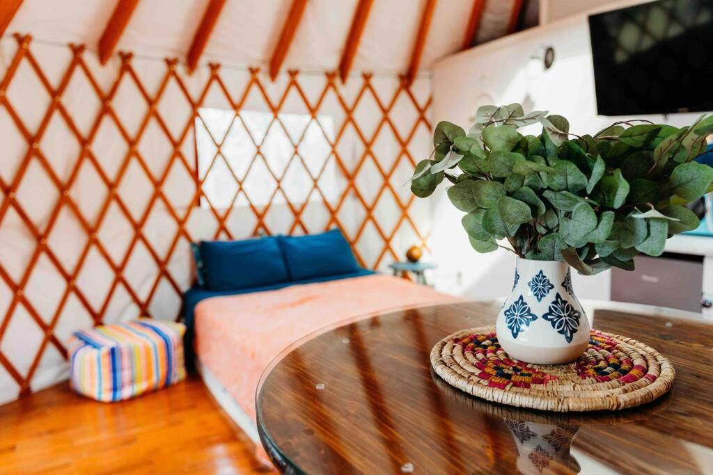 a room with a table with a vase with a plant at Heated & AC Yurt in Penn Yan