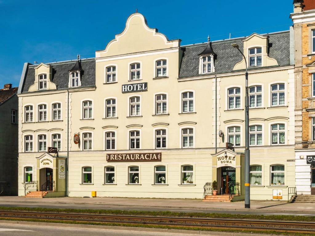 a large white building on the corner of a street at Hotel Sowa in Elblag
