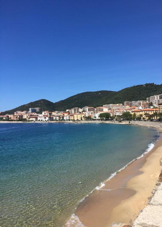 une vue d'une plage avec des maisons en arrière-plan dans l'établissement Résidence City Suites Ajaccio, à Ajaccio