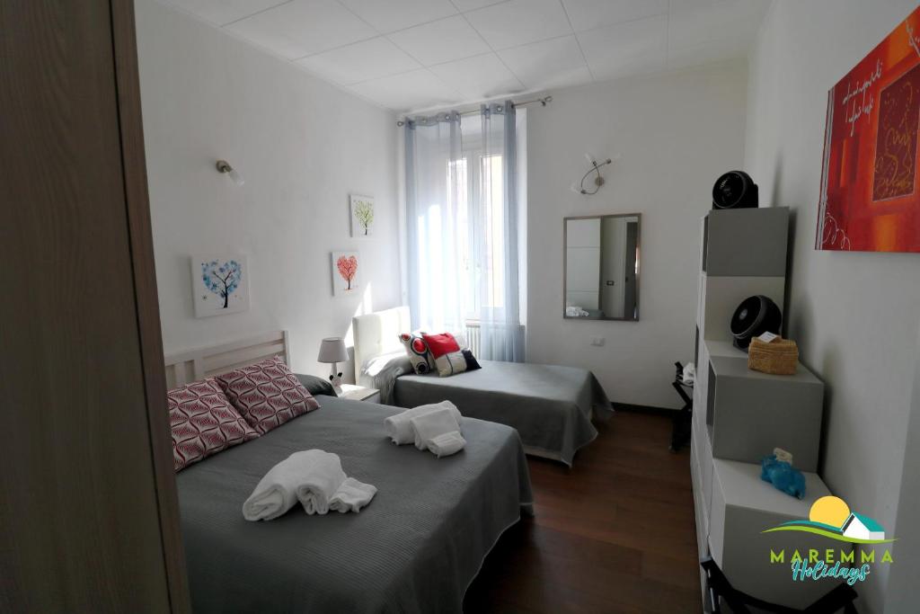 sypialnia z dwoma łóżkami i ręcznikami na nich w obiekcie Maremma Holidays -Trento Apartment w mieście Follonica