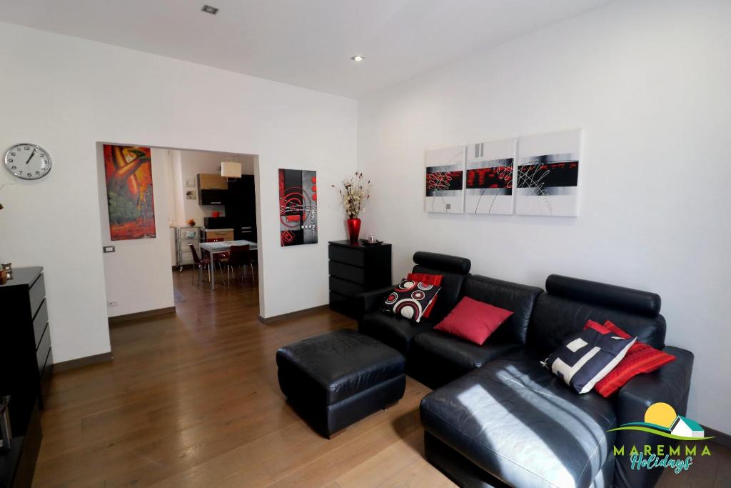 salon z czarną skórzaną kanapą w obiekcie Maremma Holidays -Trento Apartment w mieście Follonica