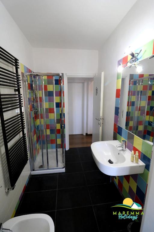 łazienka z umywalką i prysznicem w obiekcie Maremma Holidays -Trento Apartment w mieście Follonica
