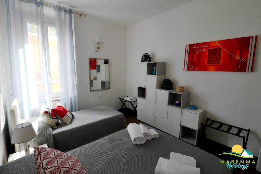 Łóżko lub łóżka w pokoju w obiekcie Maremma Holidays -Trento Apartment
