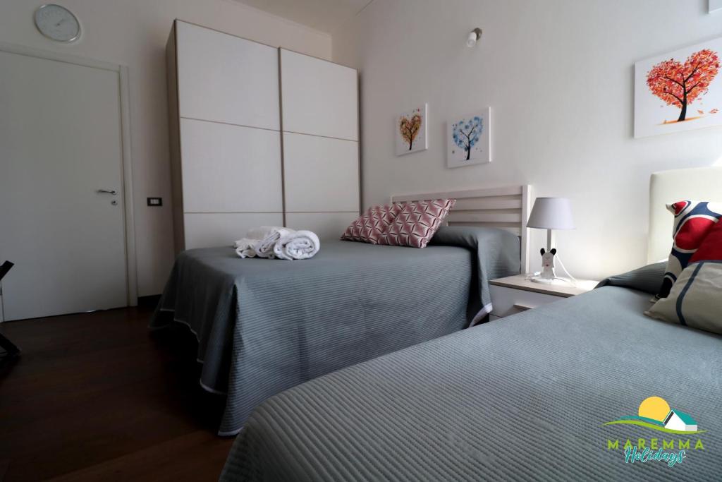 Łóżko lub łóżka w pokoju w obiekcie Maremma Holidays -Trento Apartment