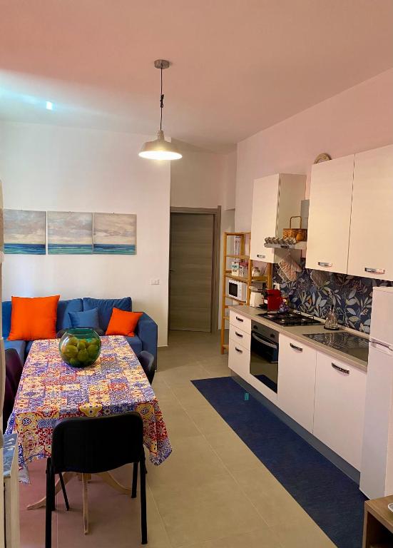 a kitchen and living room with a table and a couch at Appartamento appena ristrutturato completo di tutti i comfort a un passo dal centro in Tortolì