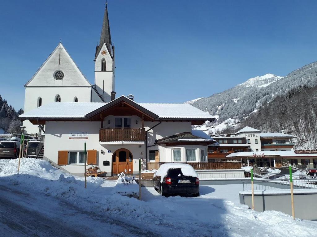 eine große weiße Kirche mit einem Kirchturm im Schnee in der Unterkunft Haus Dagmar in Silbertal