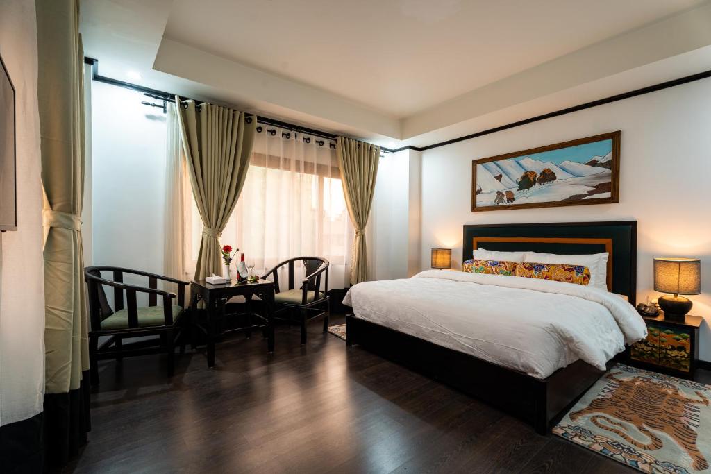 um quarto com uma cama, uma mesa e uma secretária em Hotel Lo Mustang em Kathmandu