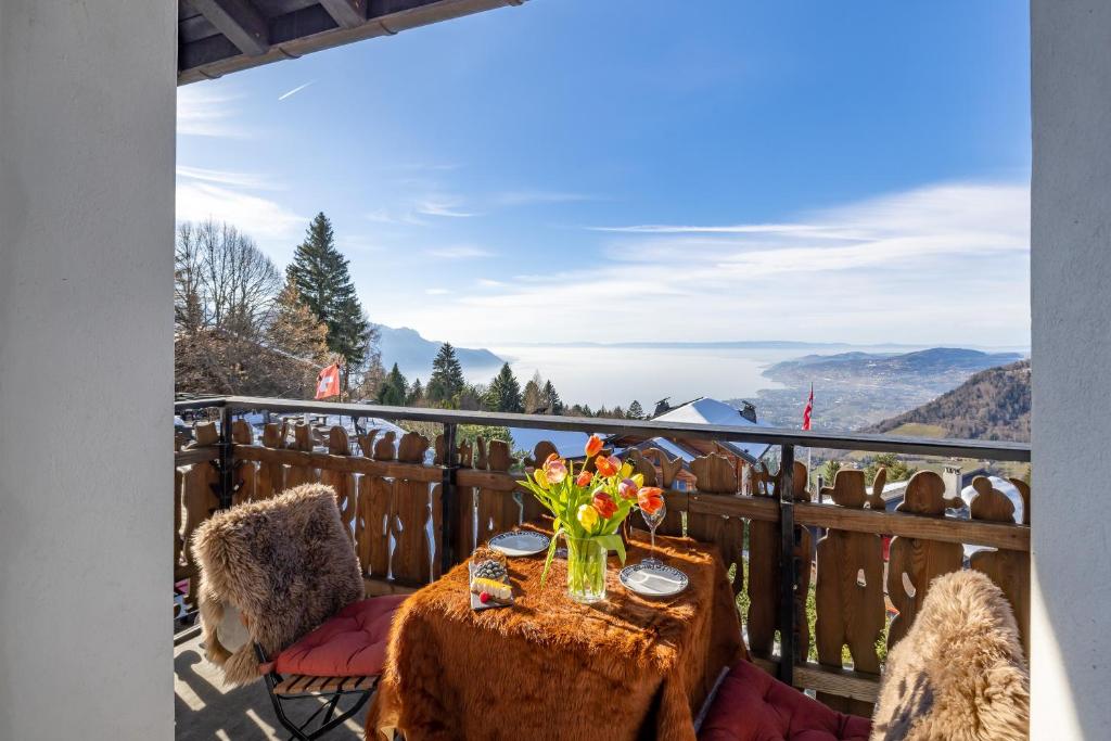 einen Tisch mit einer Blumenvase auf dem Balkon in der Unterkunft Le Coucou Hotel Restaurant & Lounge-Bar in Montreux