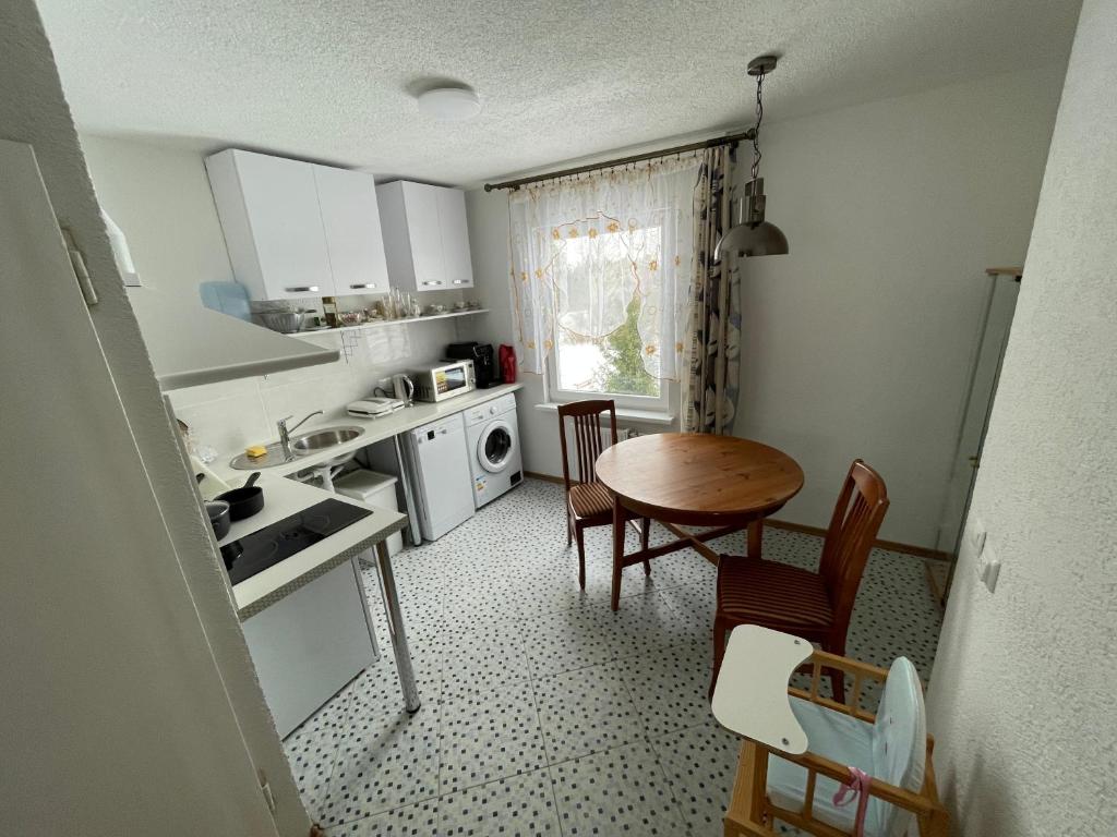 Jūrkalnes dzīvoklis في جوركالني: مطبخ صغير فيه طاولة وكراسي