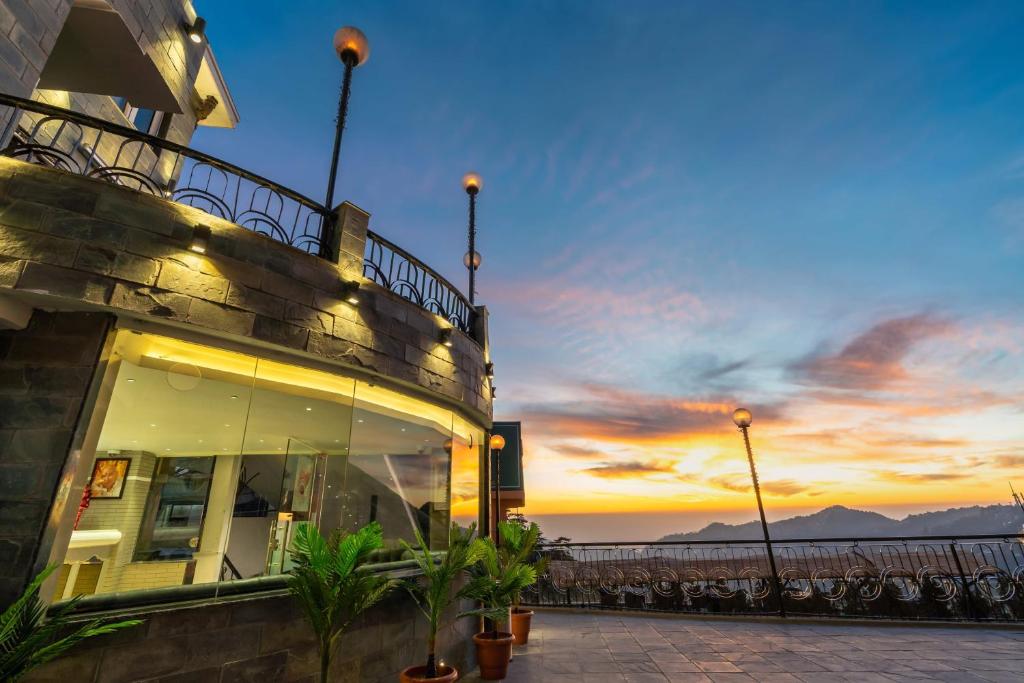 a building with a view of the ocean at sunset at Sterling Legacy Shimla in Shimla