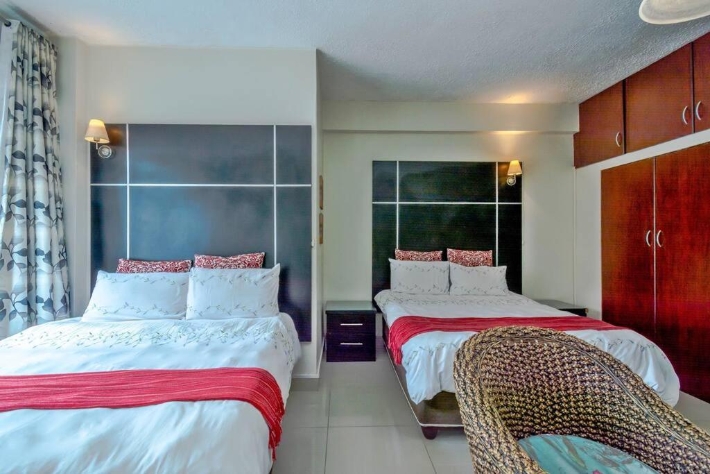 a bedroom with two beds and two chairs at Marlborough apartment 509 in Durban
