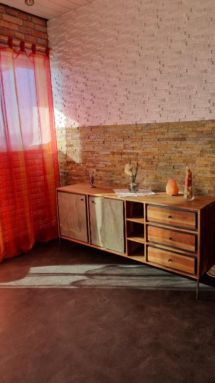 a wooden cabinet in a room with a brick wall at Modern eingerichtete 3-Zi-Ferienwohnung zu vermieten in Löffingen