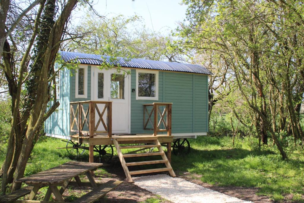 a green and white tiny house in the woods at The Woodpecker shepherd hut in Elmswell