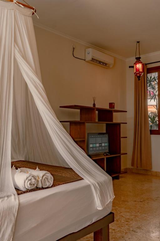 a bedroom with a bed with a mosquito net at Ecosfera Hotel & Spa in Canggu