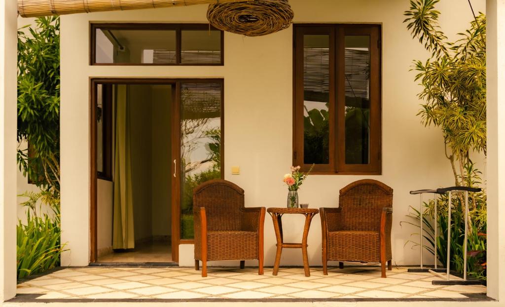 a patio with chairs and a table in front of a house at Ecosfera Hotel & Spa in Canggu