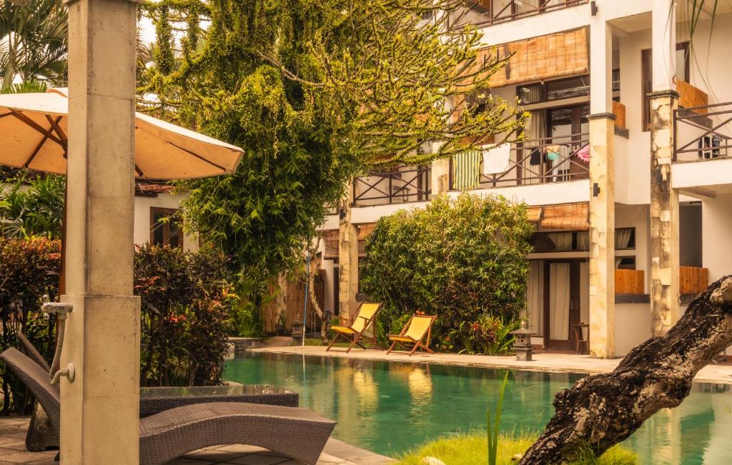 a swimming pool in front of a building at Ecosfera Hotel, Yoga & Spa in Canggu