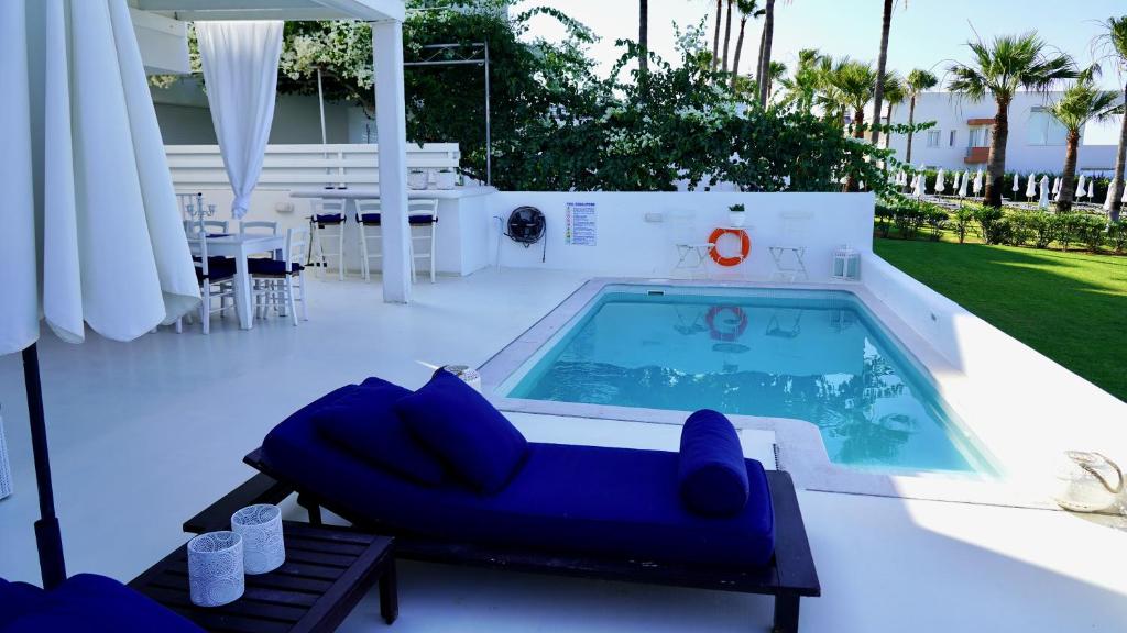 a swimming pool on a patio with a blue couch next to it at Narcissus 18 in Paralimni