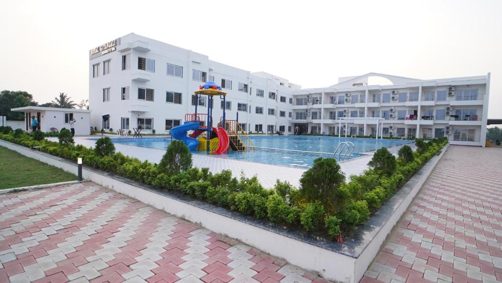 a swimming pool with a playground in front of a building at ROYAL GITANJALI RESORTS & SPA in Mandarmoni