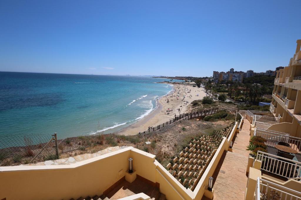 a view of the beach from the balcony of a hotel at 2 bedroom apartment at beach Dehesa de Campoamor in Dehesa de Campoamor