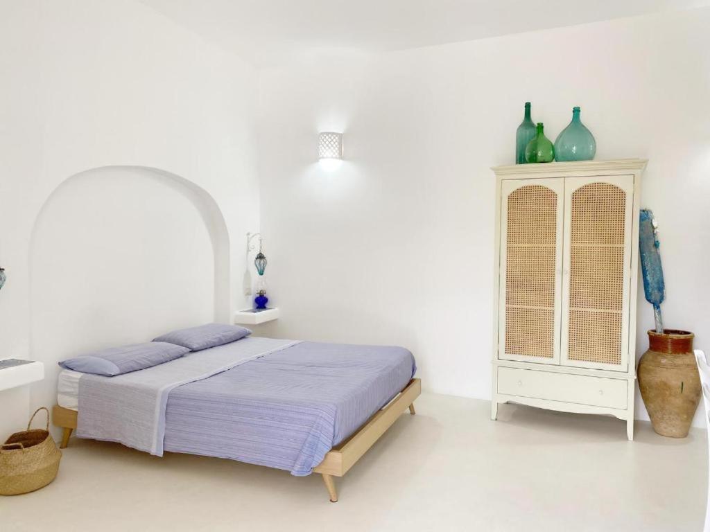 a white bedroom with a bed and a cabinet at Agata B&B in Lipari