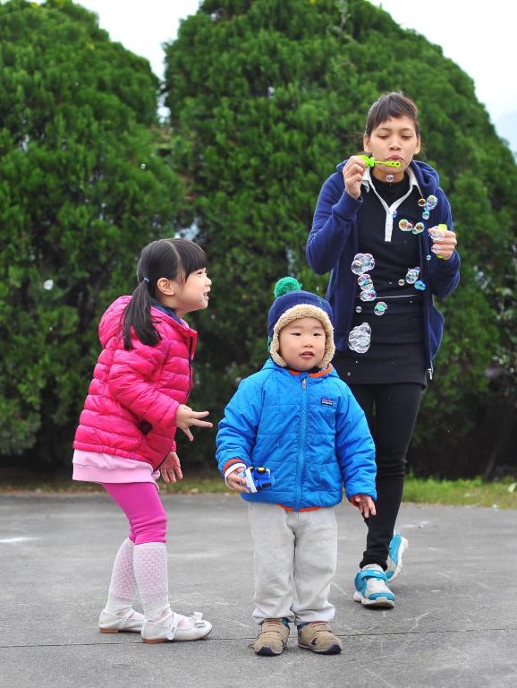two girls and a young child standing in a parking lot at Yunju House in Jiaoxi