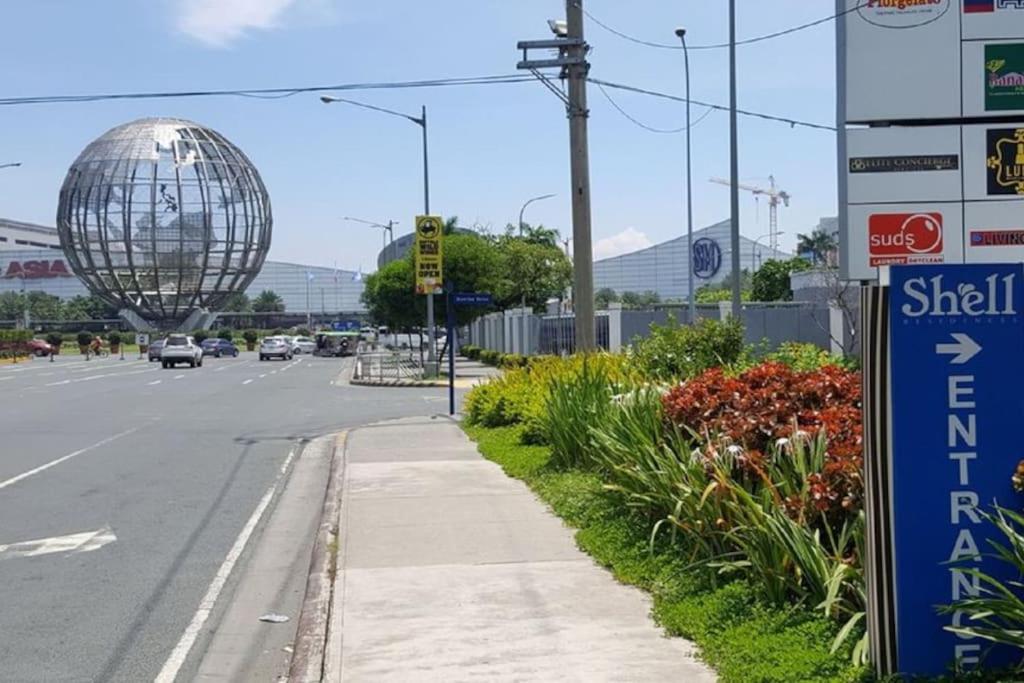 uma rua com um sinal de rua e uma esfera de metal em NEAREST MALL of ASIA Resort-facing 1BR fast wifi em Manila