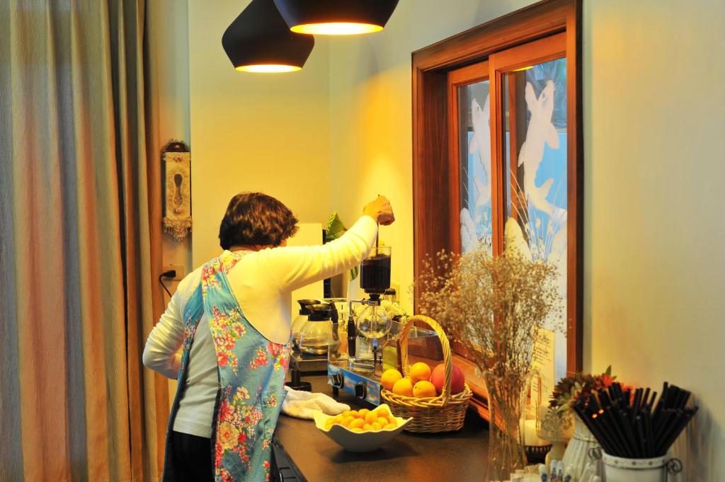 a woman standing in a kitchen looking in a mirror at Yunju House in Jiaoxi