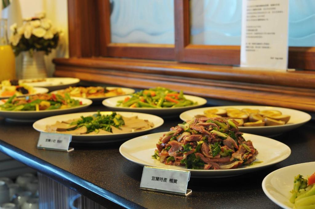 a buffet filled with plates of food on a counter at Yunju House in Jiaoxi