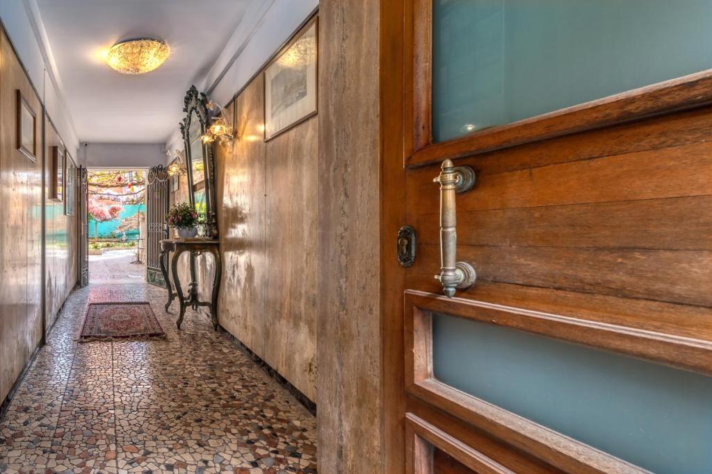 a hallway with a wooden door and a tile floor at Hotel Casa Boccassini in Venice