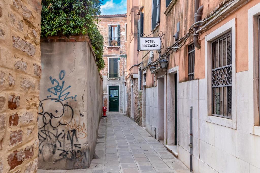 an alley with graffiti on the side of a building at Hotel Casa Boccassini in Venice