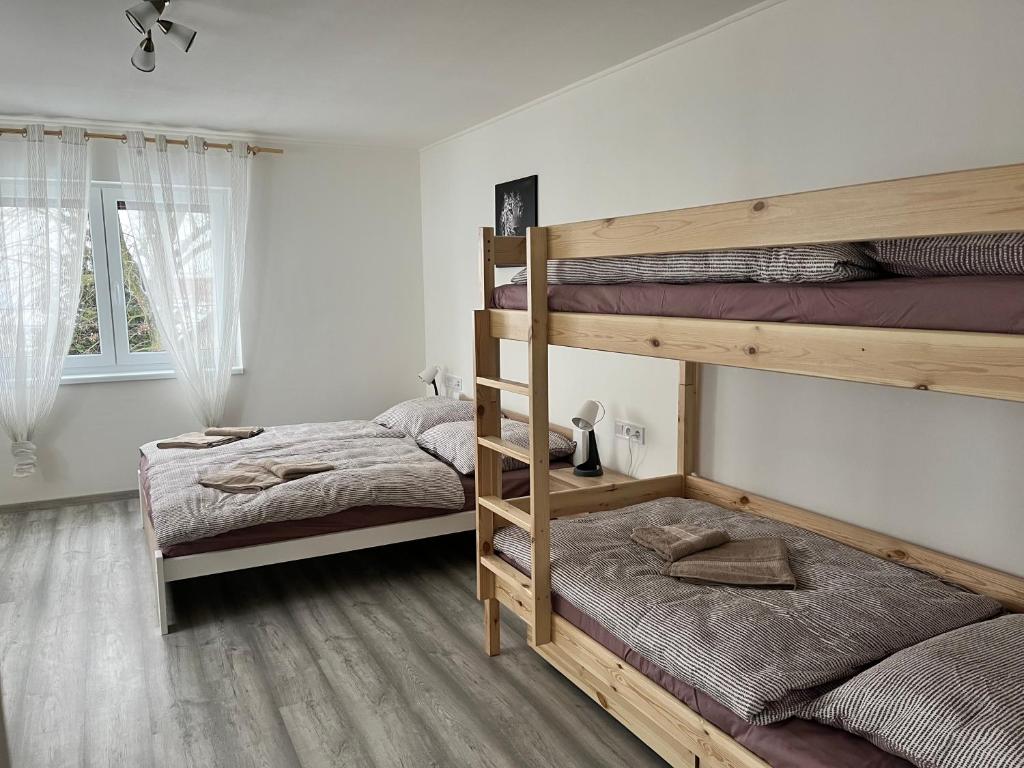 a bedroom with two bunk beds and a window at Kozákov Apartmány - druhé patro 