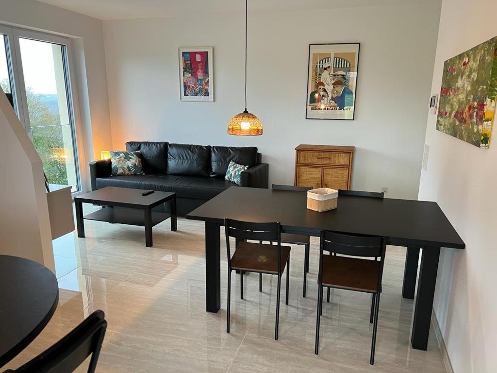uma sala de estar com uma mesa e um sofá em Résidence du Golf Eselborn em Eselborn